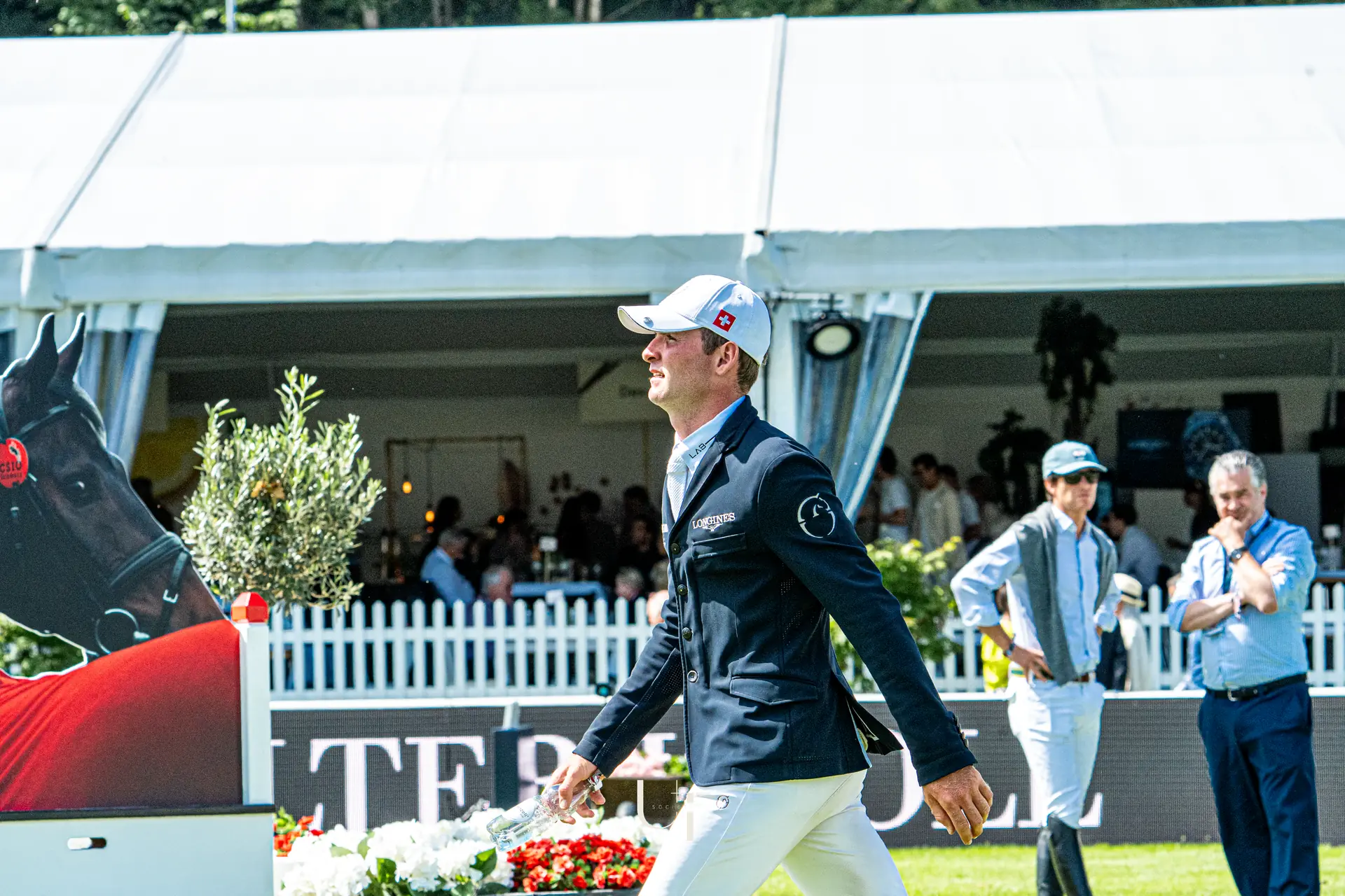 Bryan Balsiger walking the arena at a Grand Prix, hospitality tents behind him