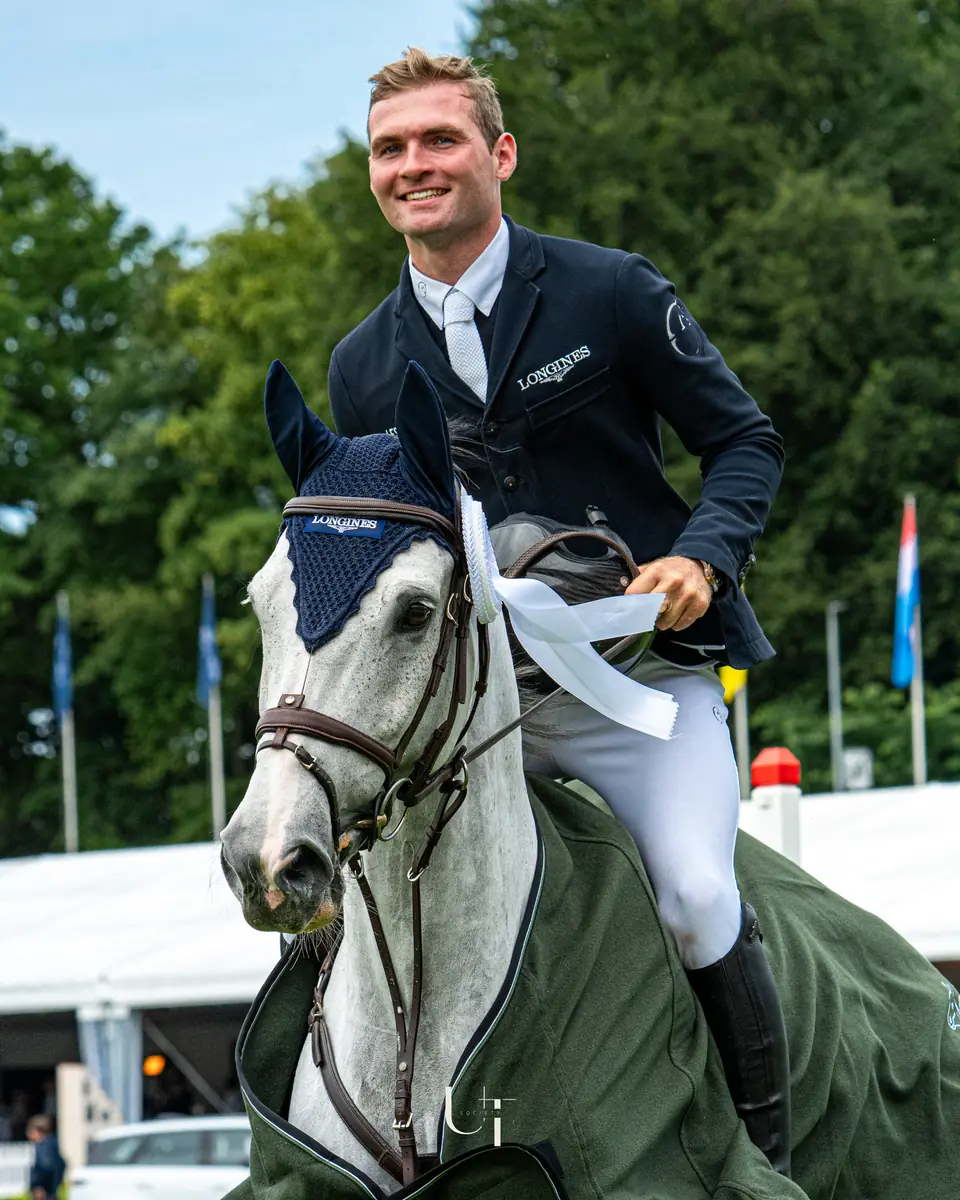 Bryan Balsiger in the saddle after a win, his grey under the winner's rug